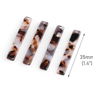 May include: Four brown and white marbled plastic rectangular pendant charms with a hole at the top. Each charm measures 1.4 inches in length.