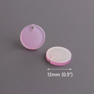 May include: Two round, translucent, pink and white acrylic charms with a hole in the center. The charms are 0.5 inches in diameter.