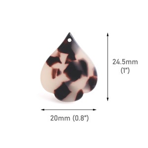 May include: A white and brown tortoiseshell plastic pendant shaped like a heart with a hole at the top. The pendant is 1 inch tall and 0.8 inches wide.