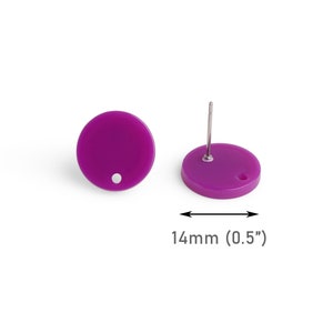 May include: Two round, purple stud earrings. Each earring is 1.4 cm in diameter and features a post for pierced ears. One earring is shown from the front, and the other is shown from the side. The earrings are set against a white background.