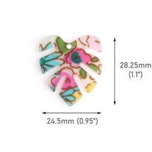 May include: A leaf-shaped charm with a floral pattern in pink, blue, green, and yellow. The charm measures 0.95 inches wide and 1.1 inches long. It has a small hole at the top for stringing.