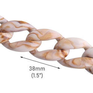 Puede incluir: Primer plano de un eslabón de cadena de plástico marmoleado blanco y marrón. El eslabón tiene 38 mm de ancho.