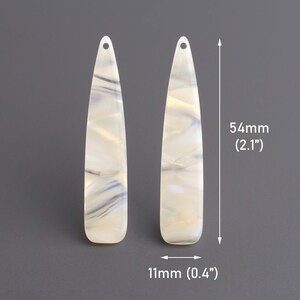 May include: A pair of white and gray marbled plastic earrings. Each earring is 2.1 inches long and 0.4 inches wide.