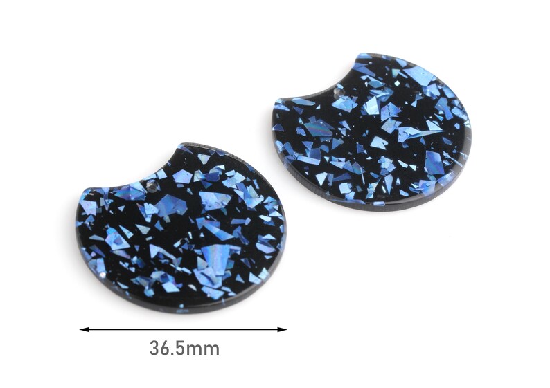 May include: Two black and blue resin half-circle shapes with a glittery finish. The shapes are 36.5 mm wide.