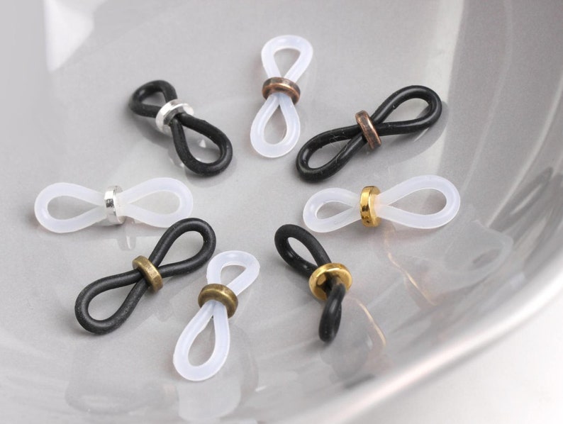 May include: Eight eyeglass chain holders, four are black and four are clear. Each holder has a metal ring in the center.