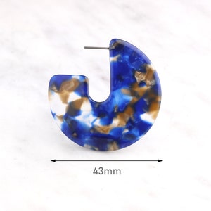 Op de afbeelding: Blauwe, witte en bruine marmeren creolen. De oorbellen hebben een diameter van 43 mm.