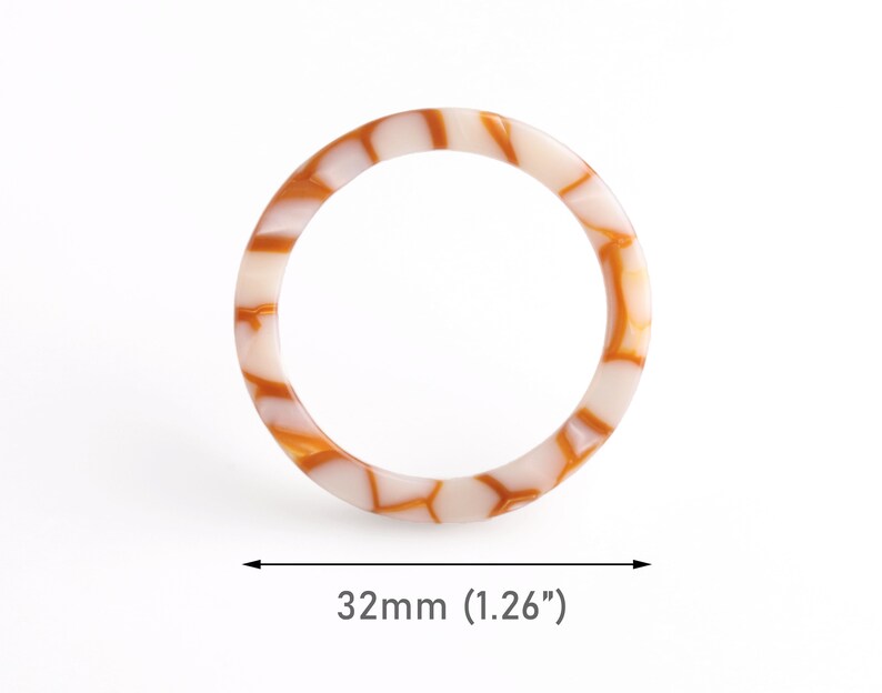 May include: A white and brown patterned bangle bracelet with a diameter of 1.26 inches.