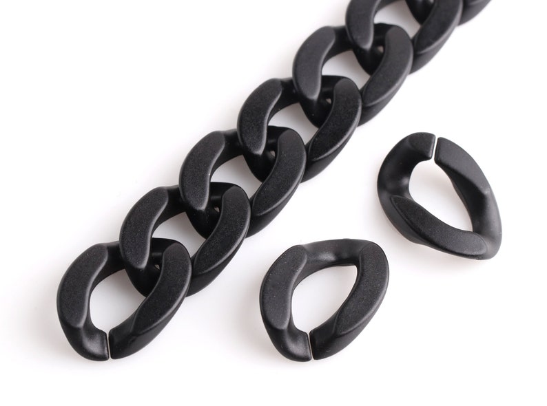 May include: A black plastic chain with two black plastic connector rings. The chain is made of large, flat links.