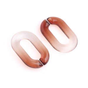 May include: Two oval-shaped, translucent brown acrylic links. The links have a gradient effect, transitioning from clear to a darker brown. The links are designed to connect, with a small opening on one side.