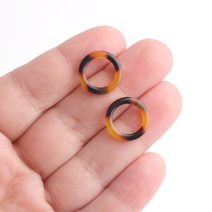 May include: Two small, round, brown and black patterned rings.