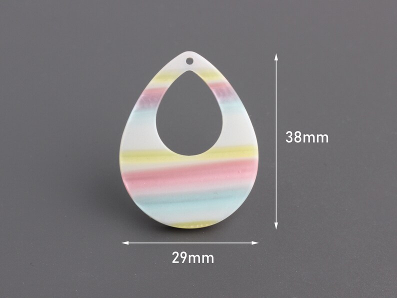 May include: A white teardrop-shaped earring with a rainbow stripe design. The earring measures 38 mm in height and 29 mm in width.