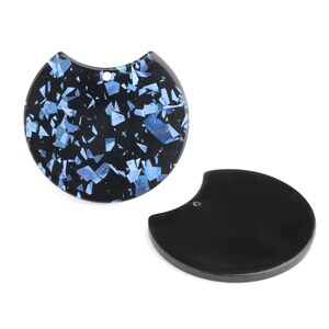 May include: Two black resin pendant charms, one with a blue and black iridescent pattern and the other solid black.