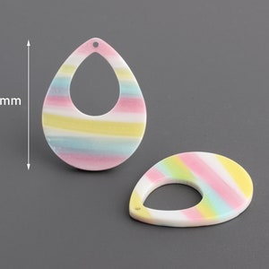 May include: Two colorful striped teardrop-shaped earrings with a hole at the top. Each earring measures 38 mm in length.