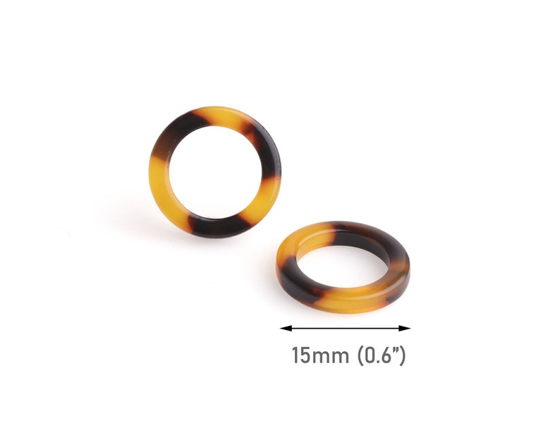 May include: Two brown and yellow tortoiseshell plastic rings, each with a diameter of 0.6 inches (15 mm).