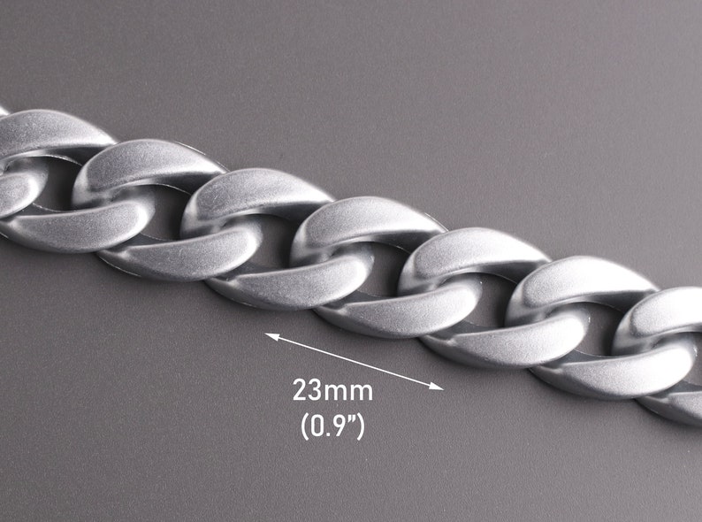 Pu&ograve; includere: Catena a curb in argento con un designo a maglie piatte e arrotondate. La catena &egrave; larga 23 mm (0,9 pollici).