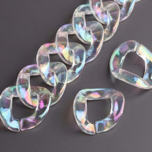 May include: A chain made of iridescent clear plastic links. The chain is made of individual links that are shaped like a rounded rectangle. The links are connected to each other by a small hole in each corner.