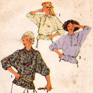 May include: A vintage sewing pattern featuring three different styles of blouses with long sleeves and a gathered waist. The blouses are shown in floral, cream, and light blue fabrics. The pattern includes instructions for sizes 1-2.