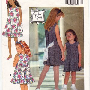 May include: A sewing pattern for a girls' dress. The pattern is for sizes 12-14 and is from Butterick. The pattern is called "Fast & Easy" and is designed by Cynthia Rowley. The pattern shows three different styles of dresses, all with a sleeveless design.