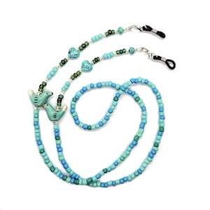 May include: A turquoise and green beaded eyeglass chain with two small bird charms and two silver heart charms.