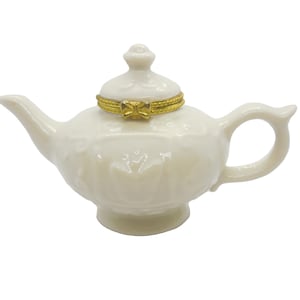Porcelain Hinged Box, Collectable Off white color Porcelain Teapot, Lid is hinged, 3. ins tall, 4.25 handle to spout, 2.5 Dia, raised design