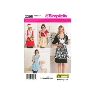 May include: A sewing pattern for three different apron styles. The aprons are shown on three models. The first apron is red with white trim and a Santa hat. The second apron is yellow with white polka dots. The third apron is black and white with a bow. The pattern is Simplicity 2298.