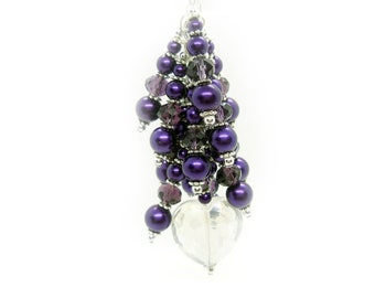 May include: A purple and silver beaded charm with a crystal heart pendant. The charm is made with small round beads and crystal beads.