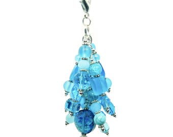 May include: A decorative charm featuring a cluster of various blue beads in shades of azure, sapphire, and sky blue. The beads include frosted, clear, and crackled glass textures, all suspended from a silver-toned metal lobster claw clasp.