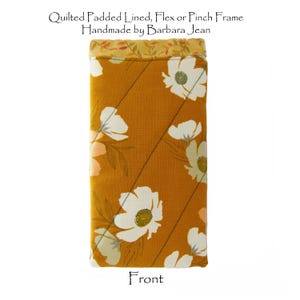 May include: A yellow and white floral patterned glasses case with a quilted lining. The case is labeled "Front" and says "Quilted Padded Lined, Flex or Pinch Frame Handmade by Barbara Jean".