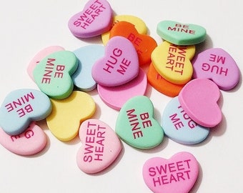 May include: A pile of colorful heart-shaped candies with various messages, including "Sweet Heart", "Hug Me", and "Be Mine".