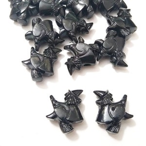 May include: A group of 18 black plastic witch figurines. The witches are wearing pointy hats and riding broomsticks.