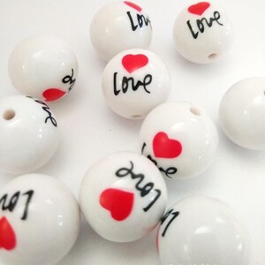 May include: White ceramic beads with a red heart and the word "Love" written in black.