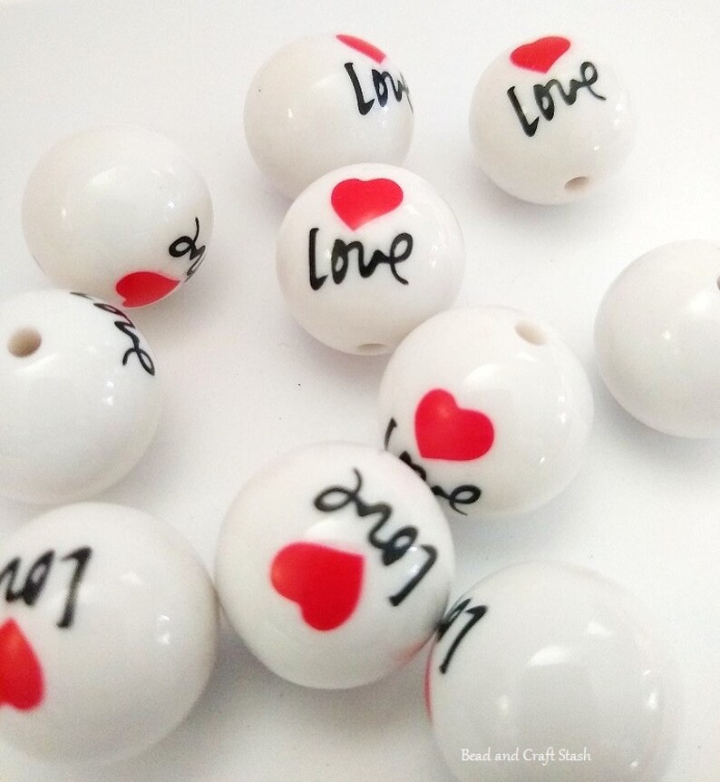 May include: White ceramic beads with a red heart and the word "Love" written in black.