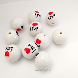 May include: White ceramic beads with a red heart and the word "Love" written in black.