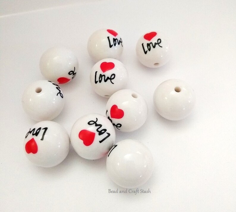 May include: White ceramic beads with a red heart and the word "Love" written in black.