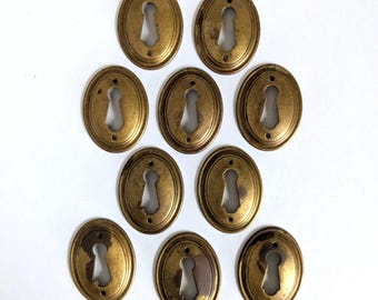 Escudo oval antigo em latão para fechadura com pátina