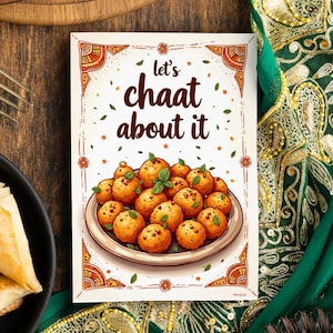 May include: A white card with an orange and brown border. The card has a cartoon illustration of a plate of fried food with the text "Let's chaat about it".