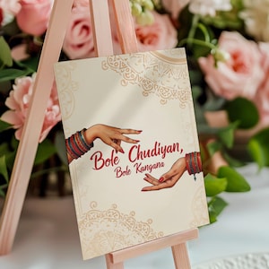 May include: A white sign with a decorative border and the text "Bole Chudiyan, Bole Kangana" in red. Two hands with red nail polish and bangles are shown on the sign.