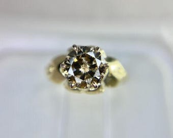 Op de afbeelding: Een gouden ring met een grote, ronde, champagnekleurige diamant.