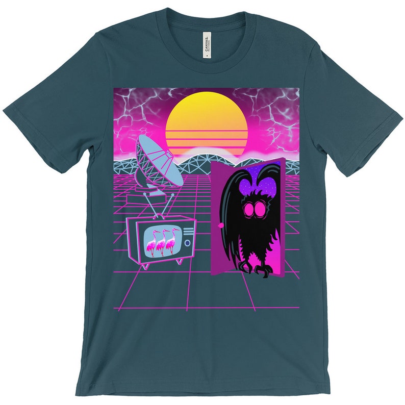May include: A teal blue t-shirt with a retro 80s design featuring a pink and purple sunset, a satellite dish, a television with pink flamingos, and a creature with large eyes emerging from a door.