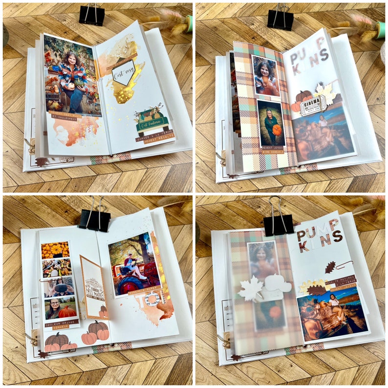 May include: A scrapbook with photos, decorative paper, and embellishments. The pages feature fall-themed images, including pumpkins and autumn foliage. The scrapbook is held together with a black binder clip and sits on a wooden surface.