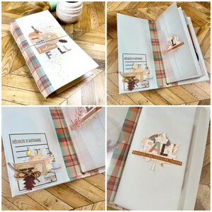 May include: A white journal with a plaid patterned spine and accents. The journal is decorated with fall-themed embellishments, including leaf cutouts and the word "FALL". The journal is tied with twine.