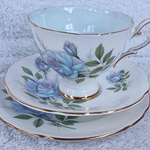 May include: A vintage teacup and saucer set with a delicate blue rose pattern and gold trim. The set is made of fine china and is in excellent condition.