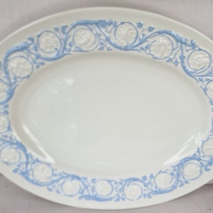 May include: A white oval serving platter with a blue and white floral design around the edge.