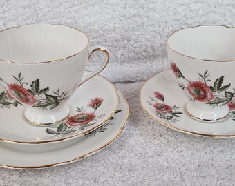 May include: Two sets of teacups and saucers with a floral pattern. The cups and saucers are white with a gold trim and feature pink and green flowers.