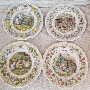 Puede incluir: Cuatro platos decorativos con bordes festoneados. Cada plato presenta una escena diferente con personajes de animales y bordes florales. Los platos se titulan "The Outing", "The Invitation", "The Meeting" y "The Plan".