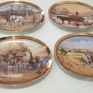 Puede incluir: Conjunto de cuatro platos decorativos ovalados con borde dorado. Cada plato presenta una escena diferente de caballos tirando de un carro o un arado en un entorno rural. Los platos son blancos con un acabado brillante.