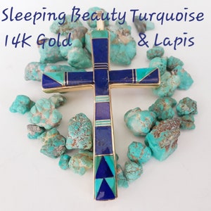 K&ouml;nnte beinhalten: Ein goldener Kreuzanh&auml;nger mit Sleeping Beauty T&uuml;rkis und Lapislazuli. Das Kreuz ist von rohen T&uuml;rkissteinen umgeben. Der Text "Sleeping Beauty Turquoise & Lapis" und "14K Gold" ist im Bild zu sehen.