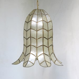 May include: A white shell pendant light fixture with a gold metal frame. The fixture has a bell shape with a scalloped bottom.