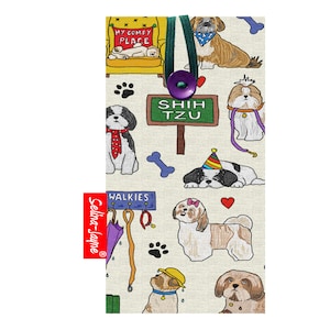 May include: A white fabric pouch with a colourful pattern of Shih Tzu dogs. The pouch has a green zipper and a purple button. The text "Shih Tzu" is on a green sign. The text "Selma-Jayne" is on a red label.