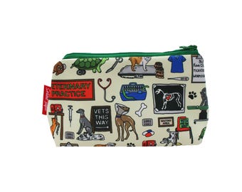 May include: A cream-colored zippered pouch with a green zipper and trim, featuring a veterinary theme. The design includes illustrations of dogs, a turtle, medical tools, and the text "VETERINARY PRACTICE" and "VETS THIS WAY".